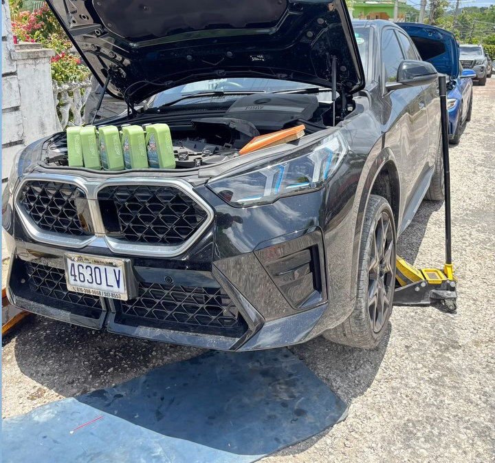 A BMW X2 being serviced at JRC Automotive, oil cans lined up on the grille