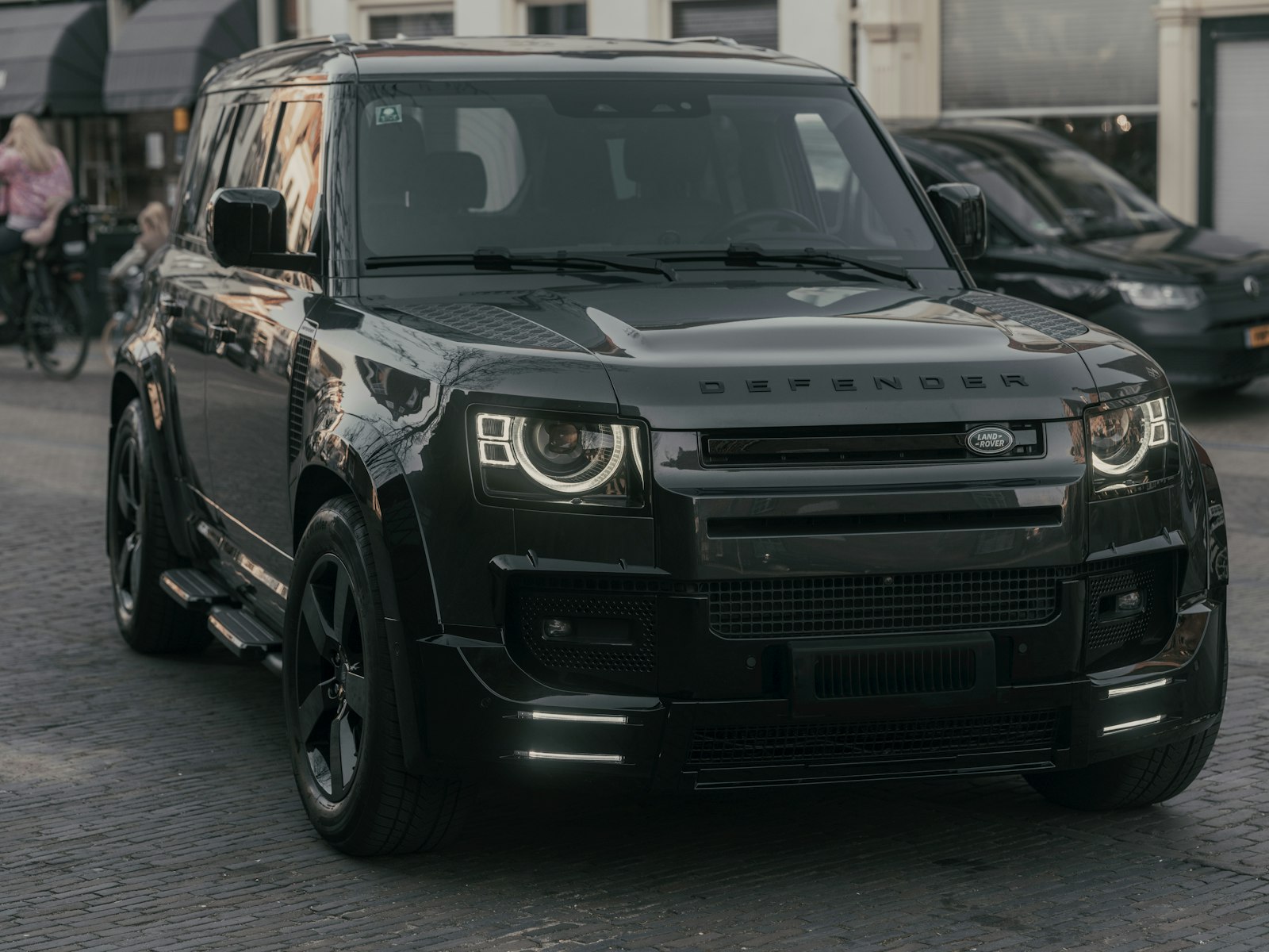 A black Land Rover Defender on a city street